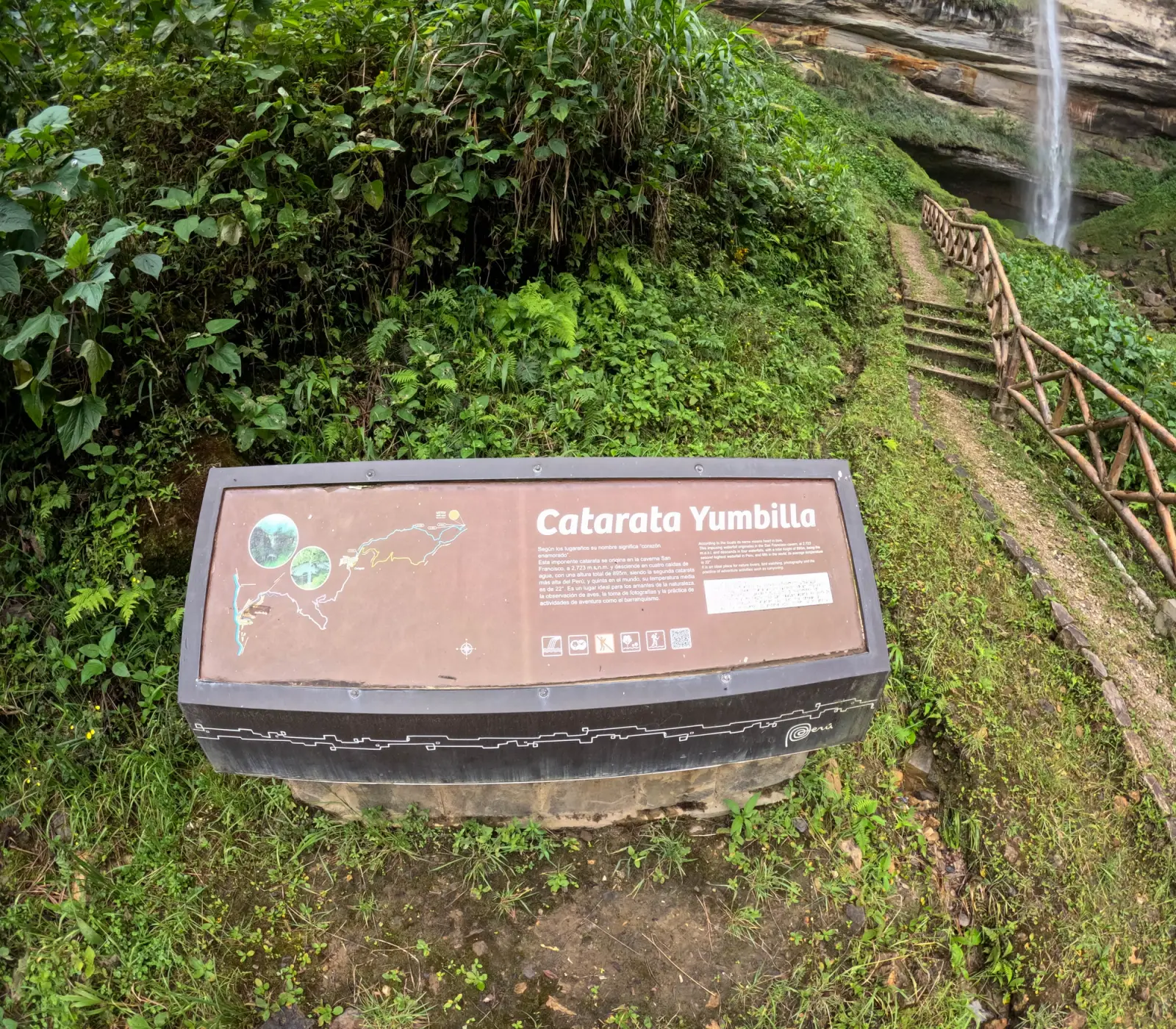 Letrero interpretativo de la catarata Yumbilla con la caída de agua al fondo