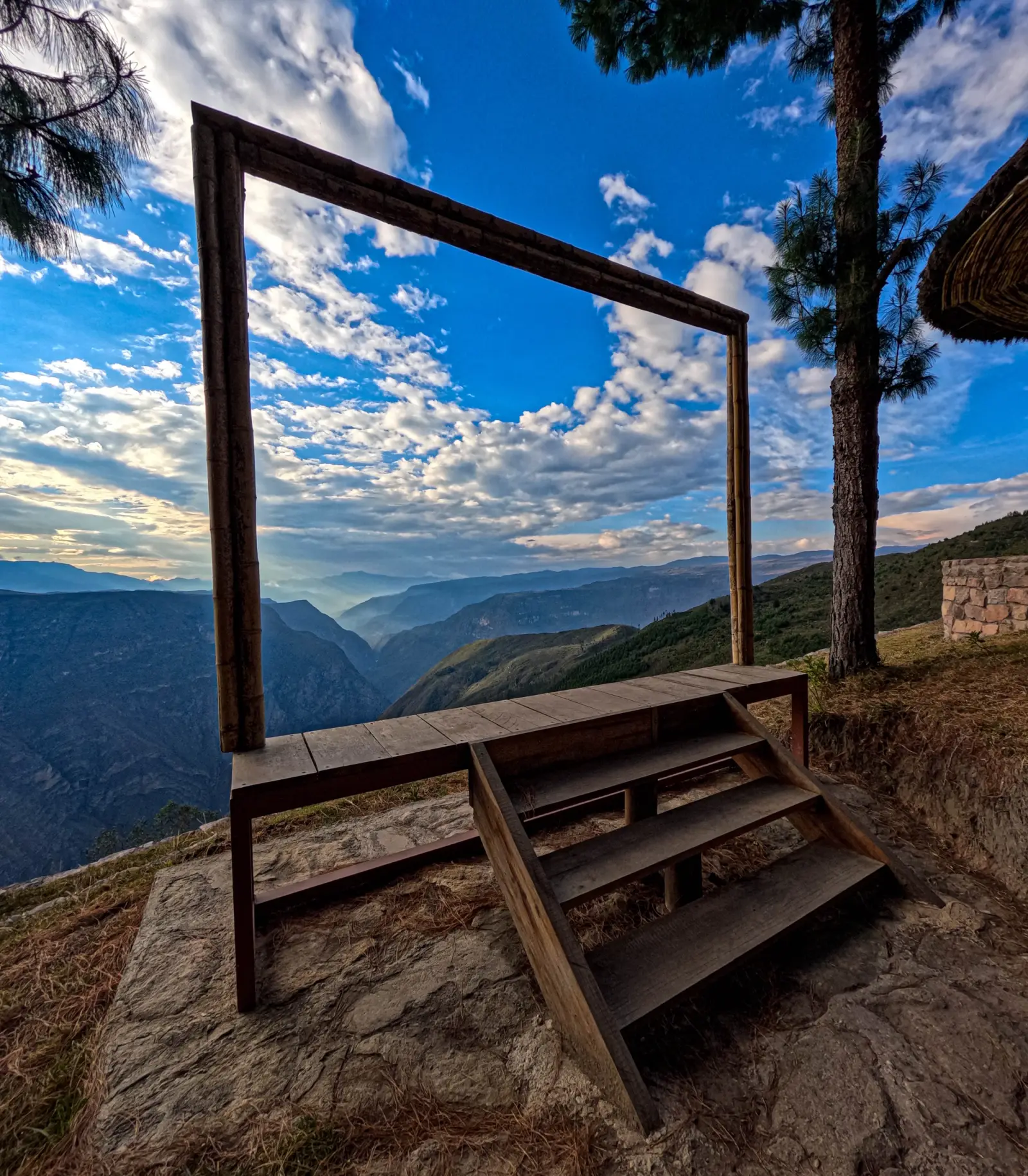 Marco de madera para fotos en un mirador frente a montañas y valles