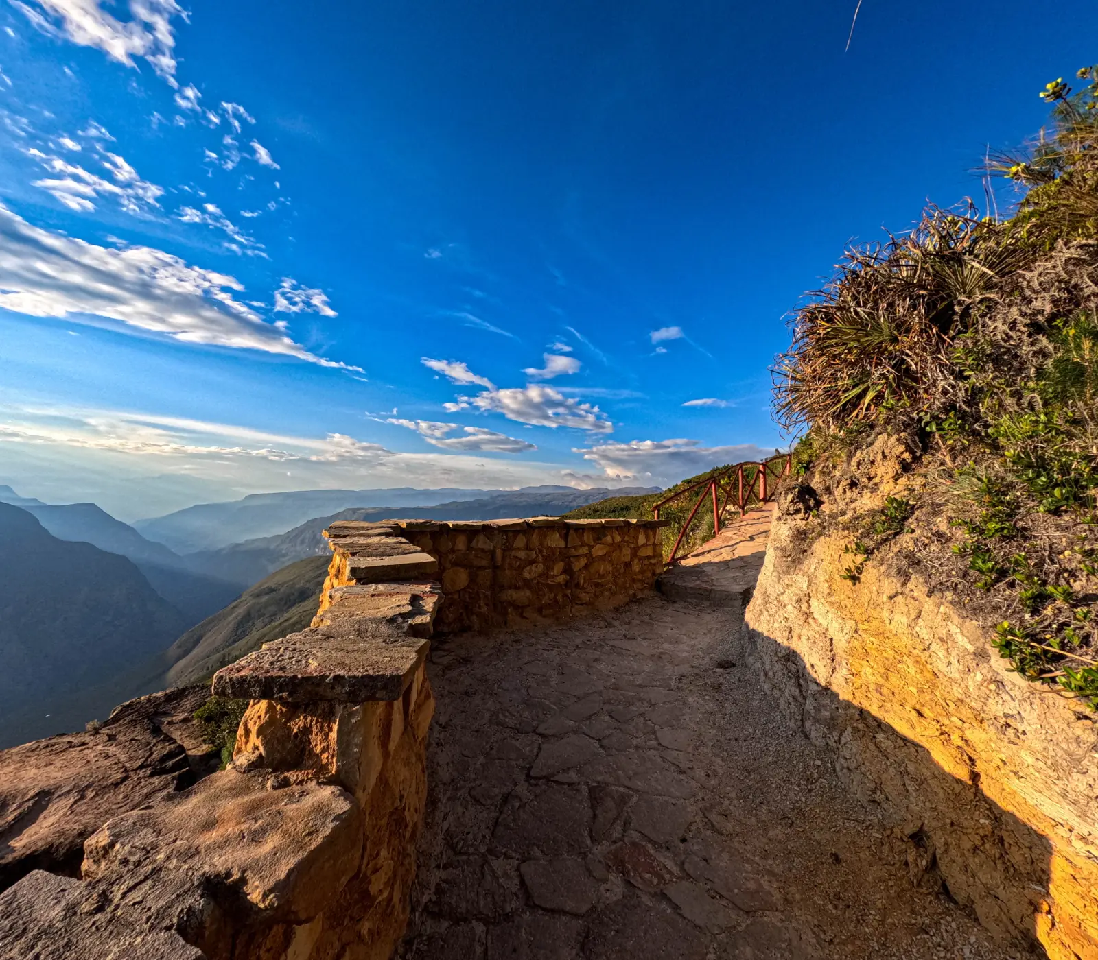 Camino empedrado con muro de piedra al borde del cañón del Sonche