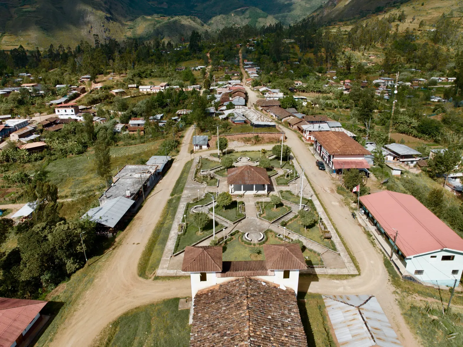 Vista aérea de un pueblo con su plaza central, casas y calles de tierra