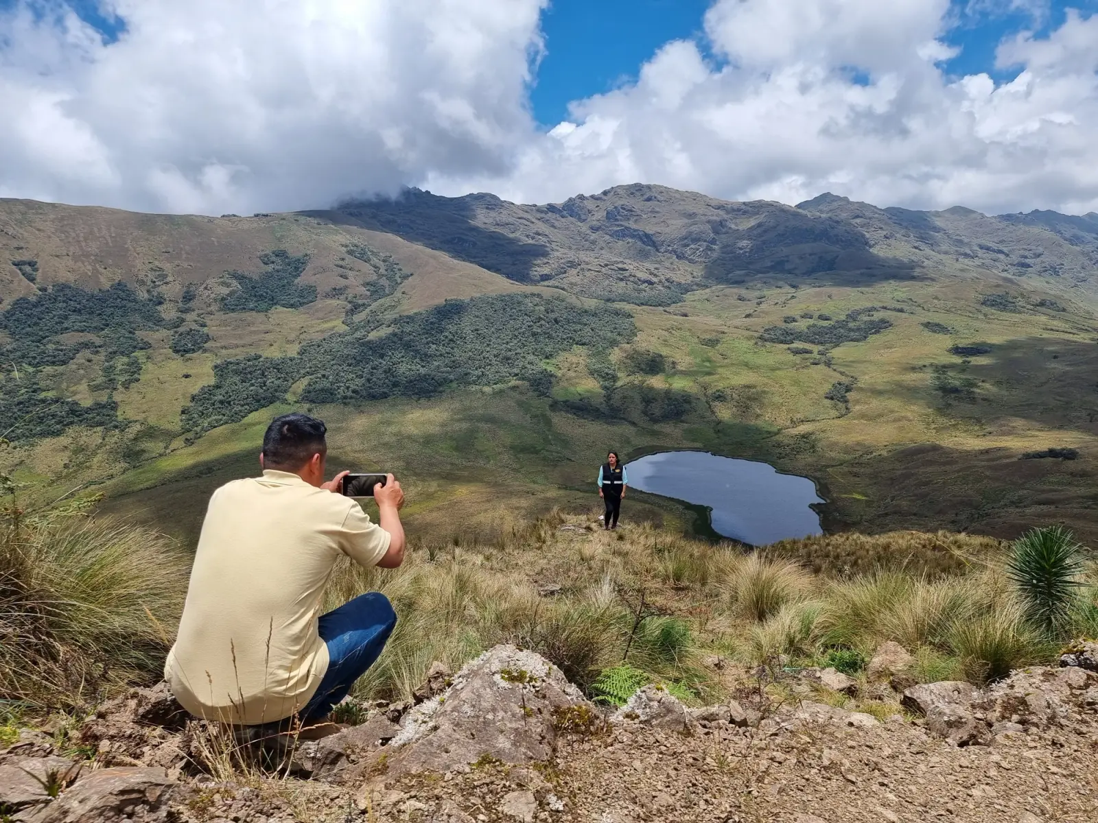 Visitante fotografiando a otra persona en la ladera sobre la laguna Cuchacuella