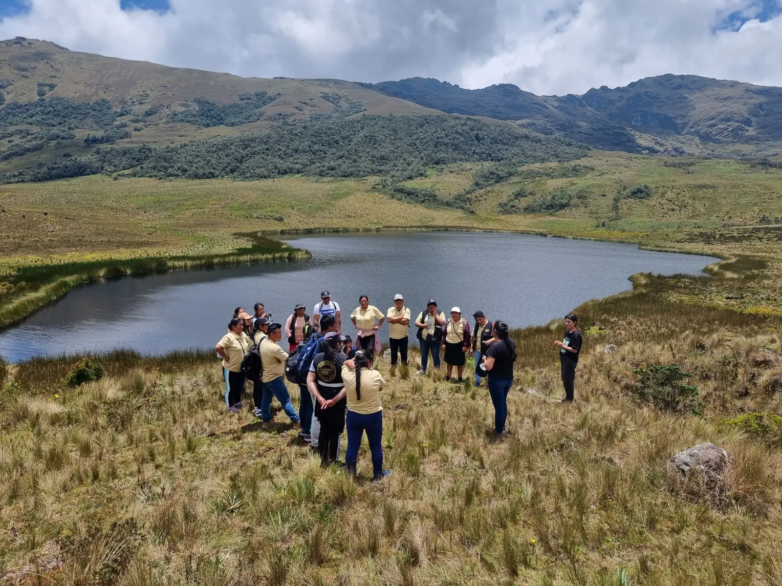Grupo de visitantes reunido a orillas de la laguna Cuchacuella entre pajonales