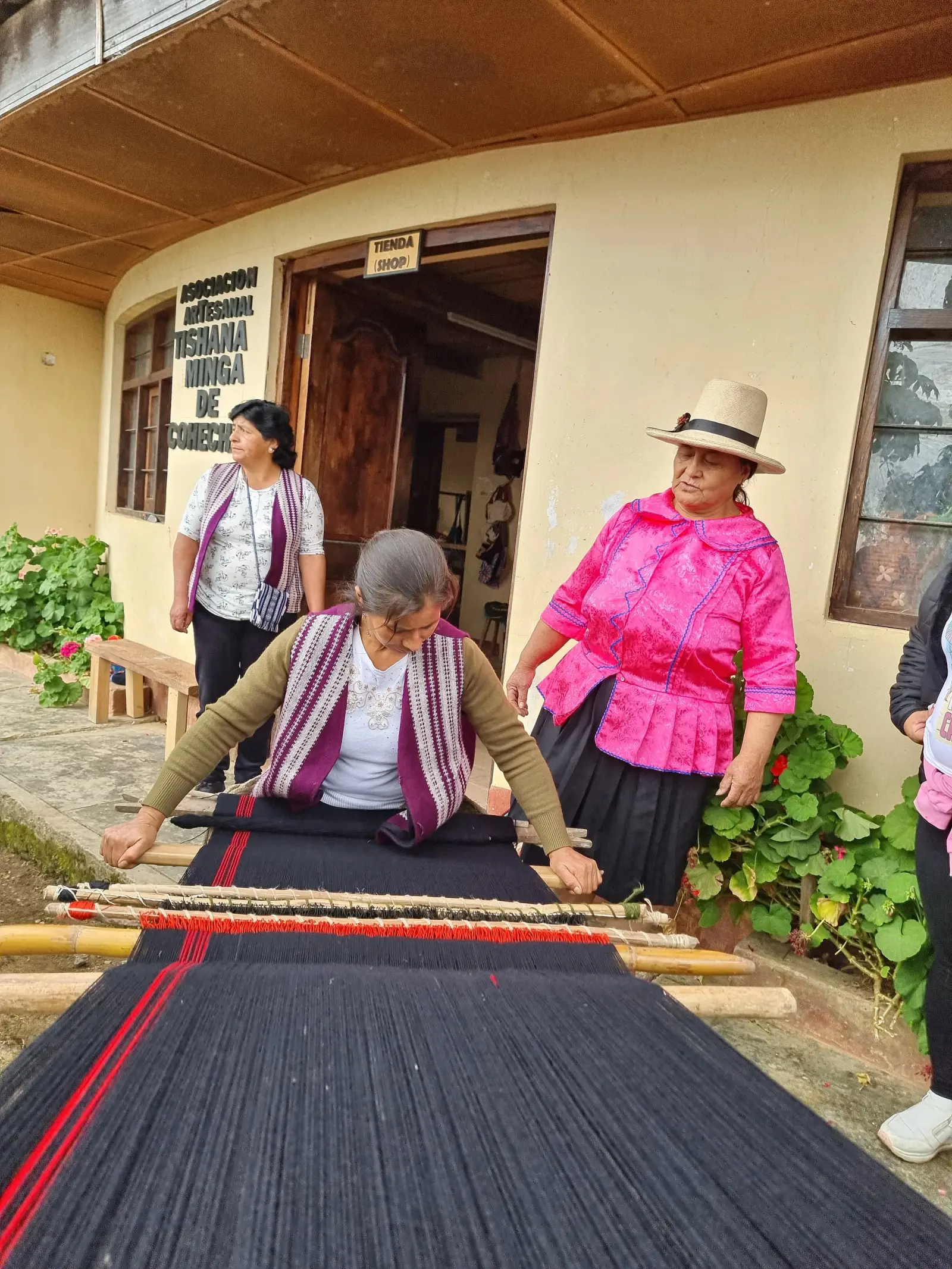 Artesana tejiendo en telar frente al local de la Asociación Tishana Minga de Cohechán